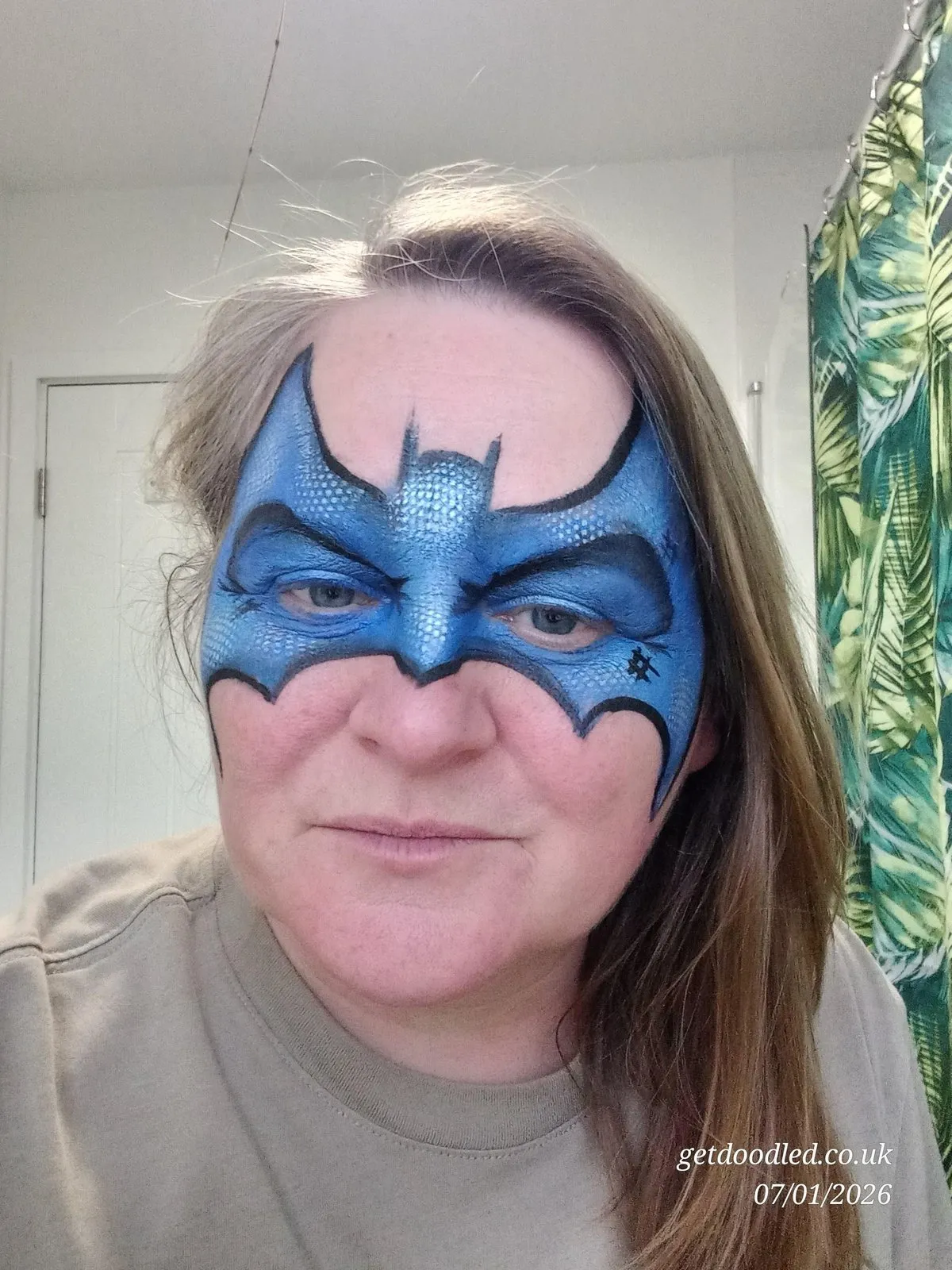 A blue Batman-style superhero mask face paint