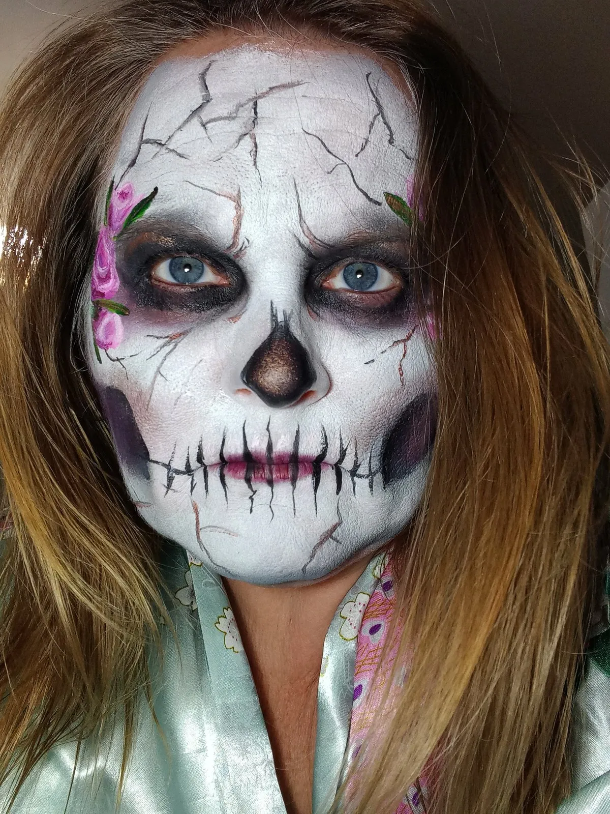 A cracked porcelain skull face with painted roses