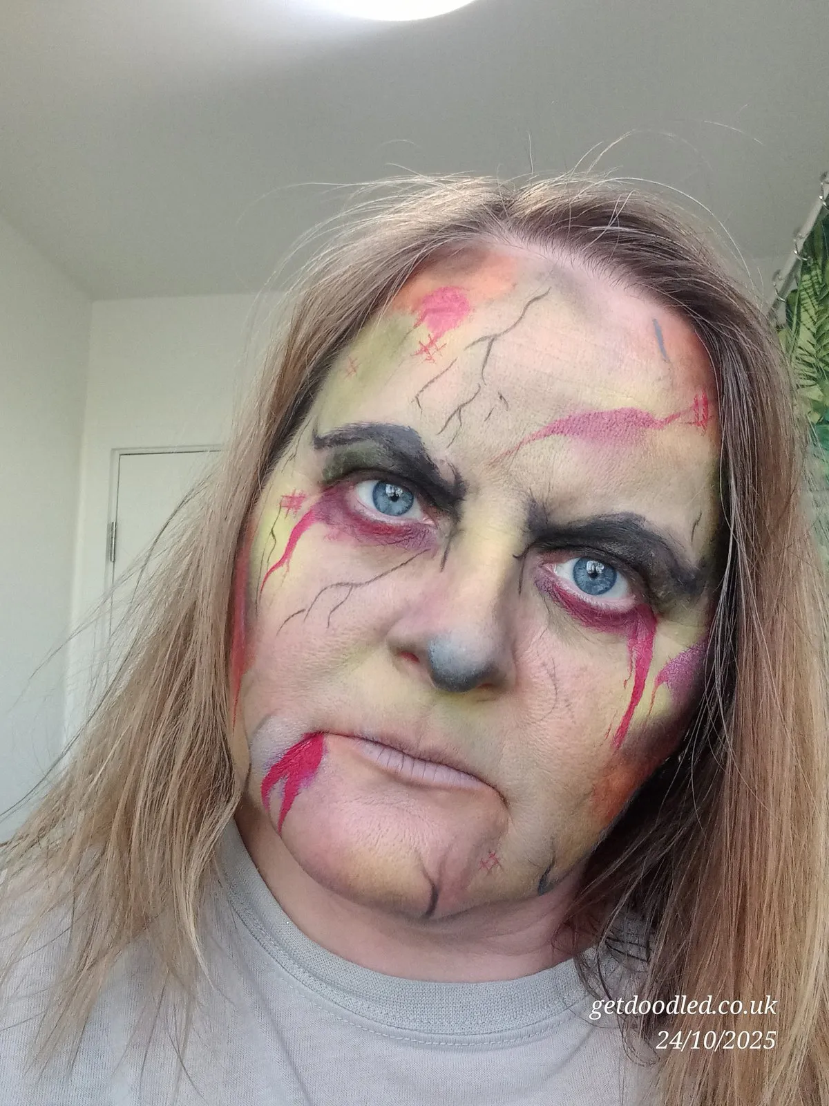A cracked doll face in pinks and greys