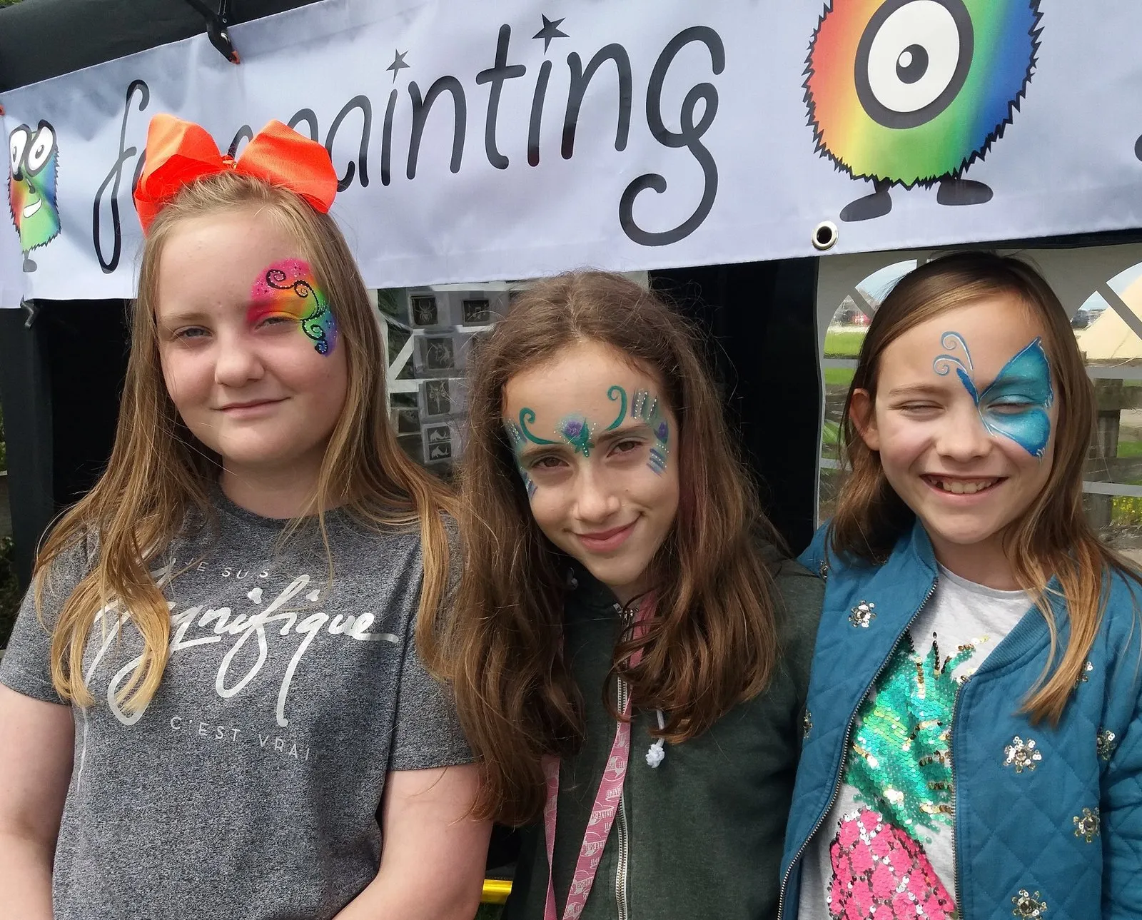 Three friends with matching eye designs at an event