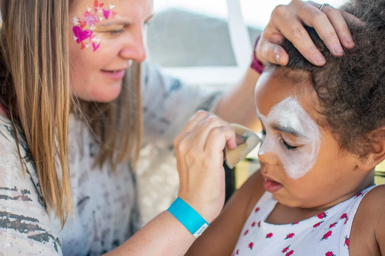 Christine painting a child's face at an event stall