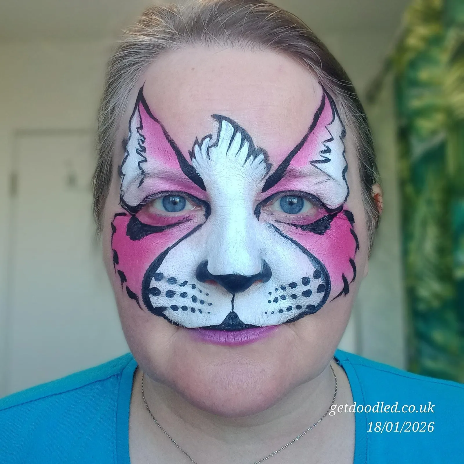 A pink and white cat face design