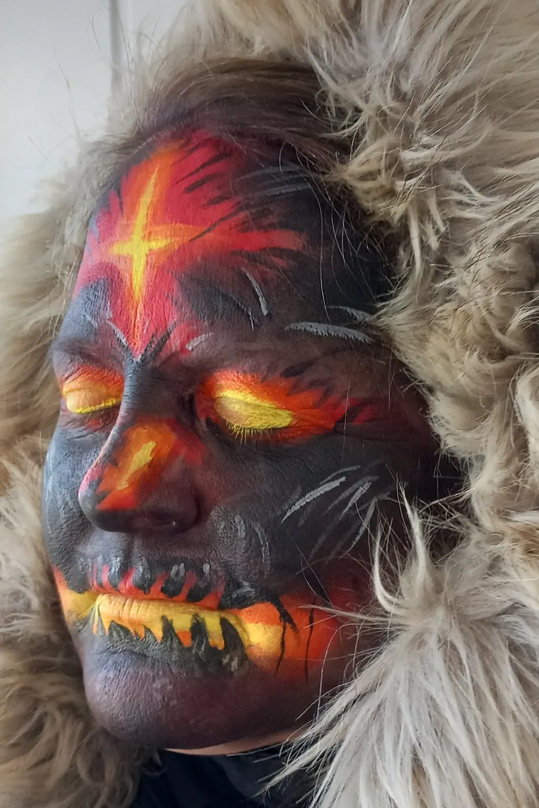 A dark demon face with glowing orange lava cracks