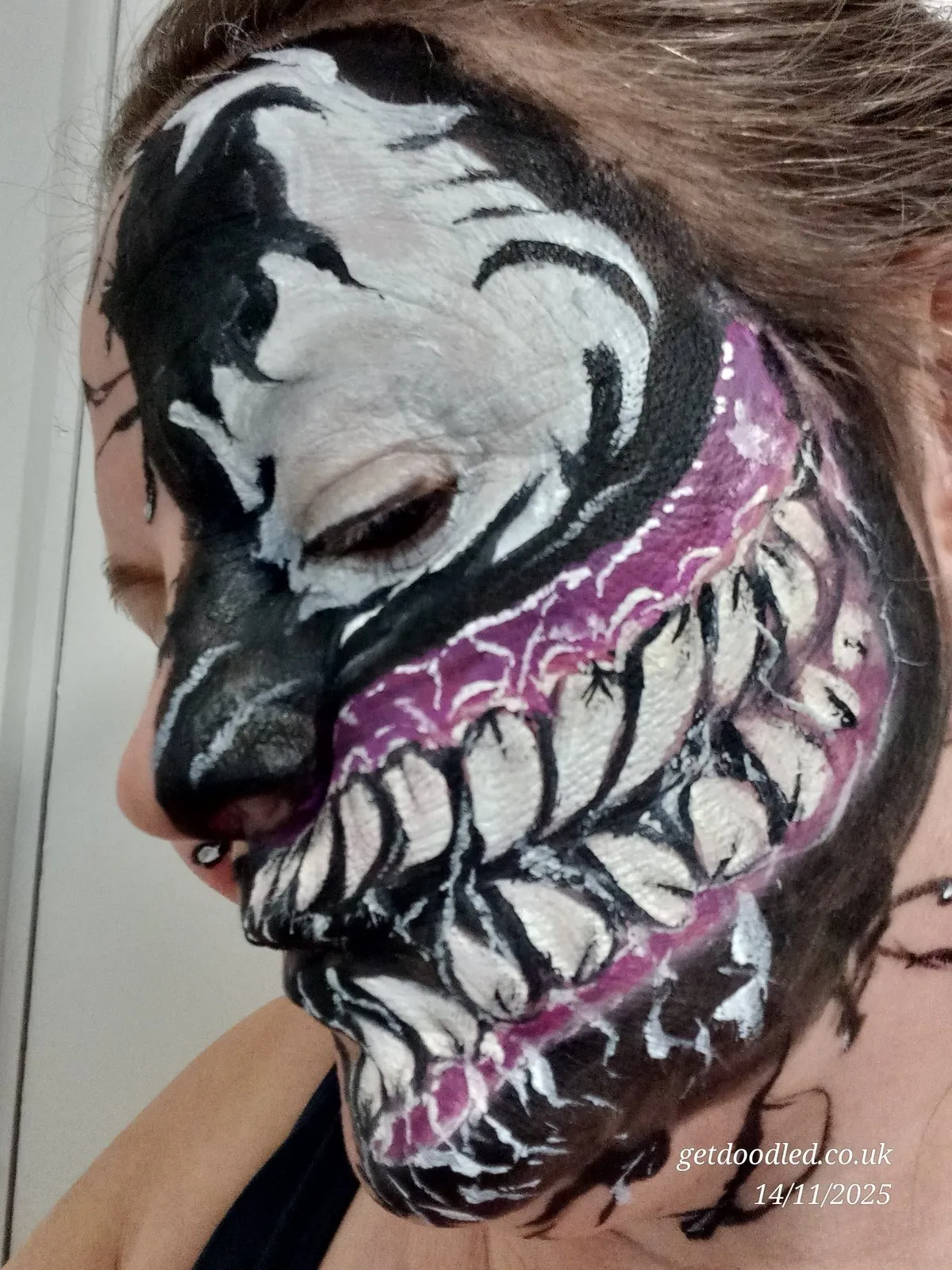 A monster jaw design with bared teeth in black, white and purple