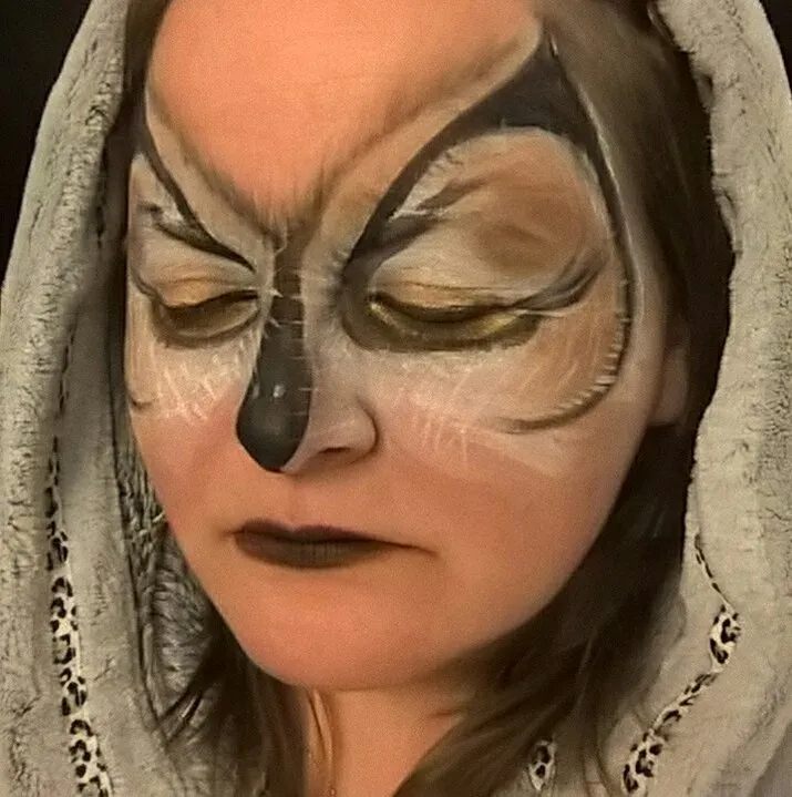 An artistic owl face paint in browns and cream