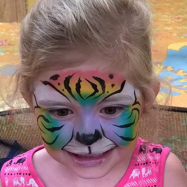 A girl painted as a bright rainbow tiger
