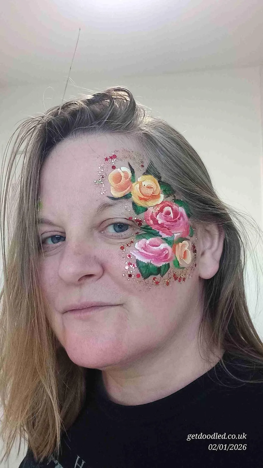 Painted roses and glitter across the cheek