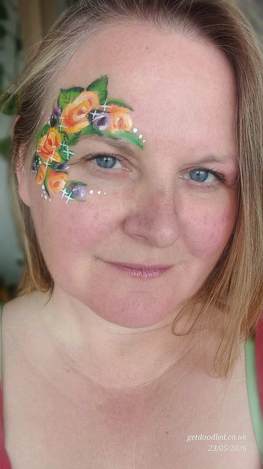 Painted roses and glitter across the cheek and eye