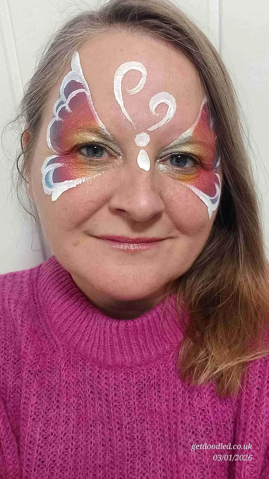 A delicate white and pink butterfly forehead design