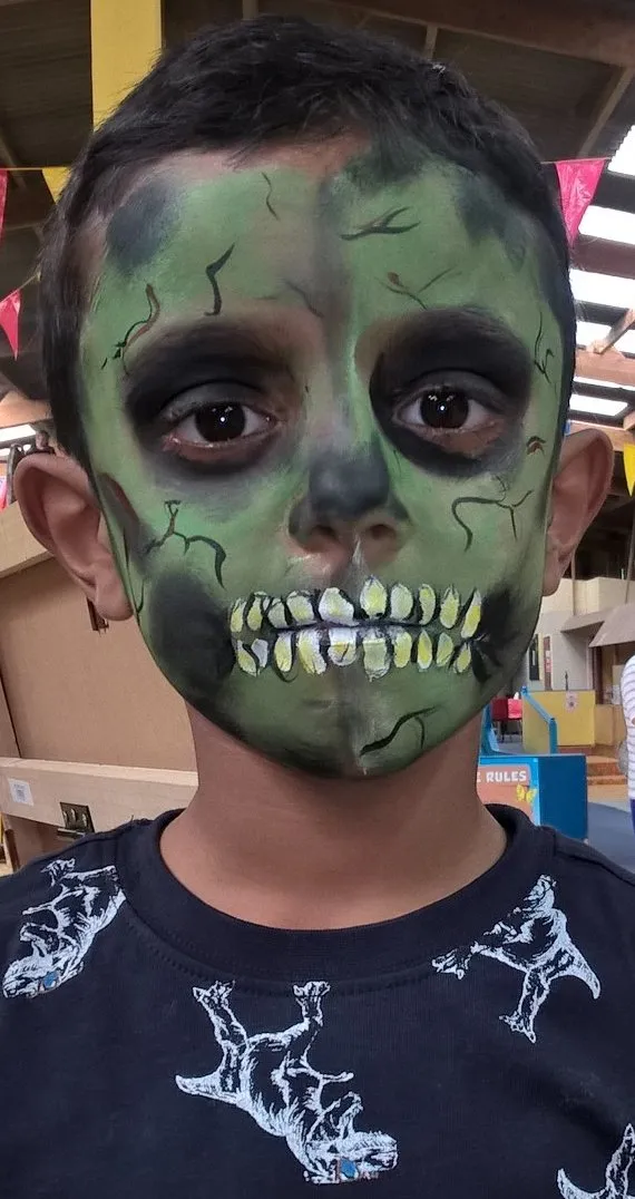 A boy painted as a green zombie