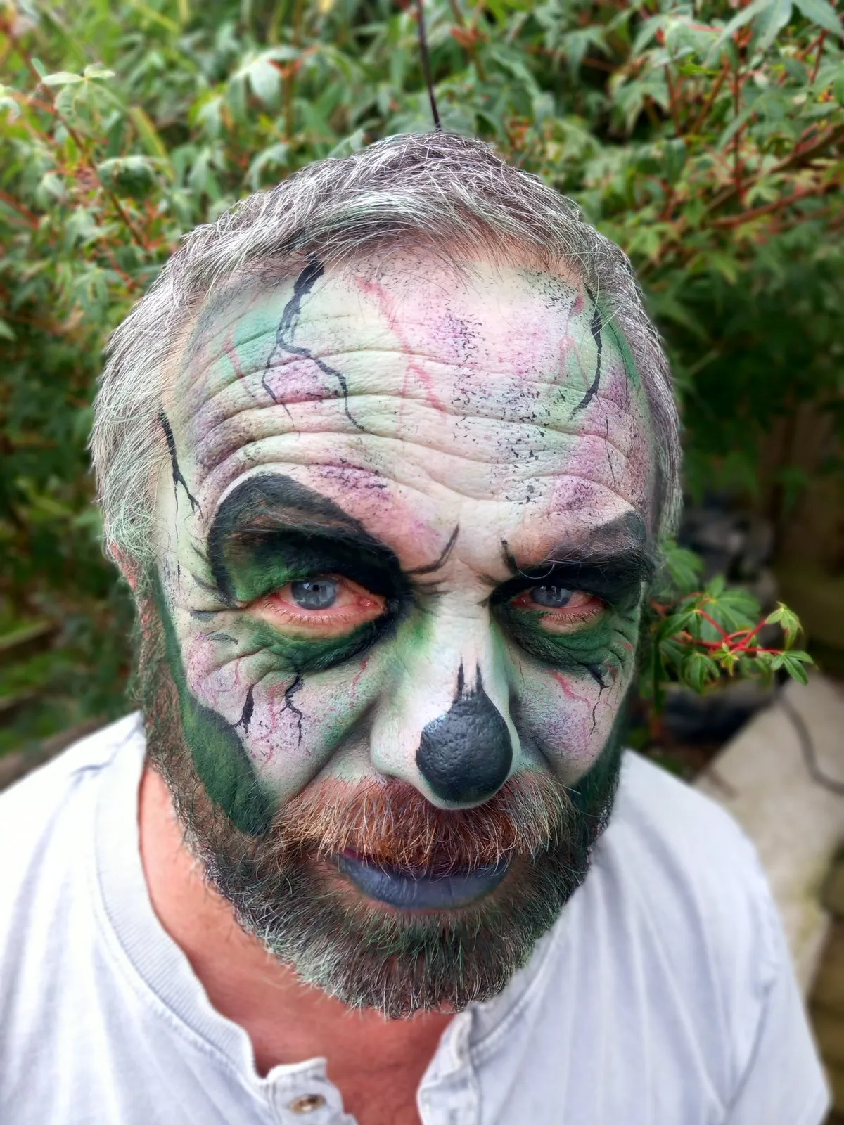 A man painted as a green cracked zombie